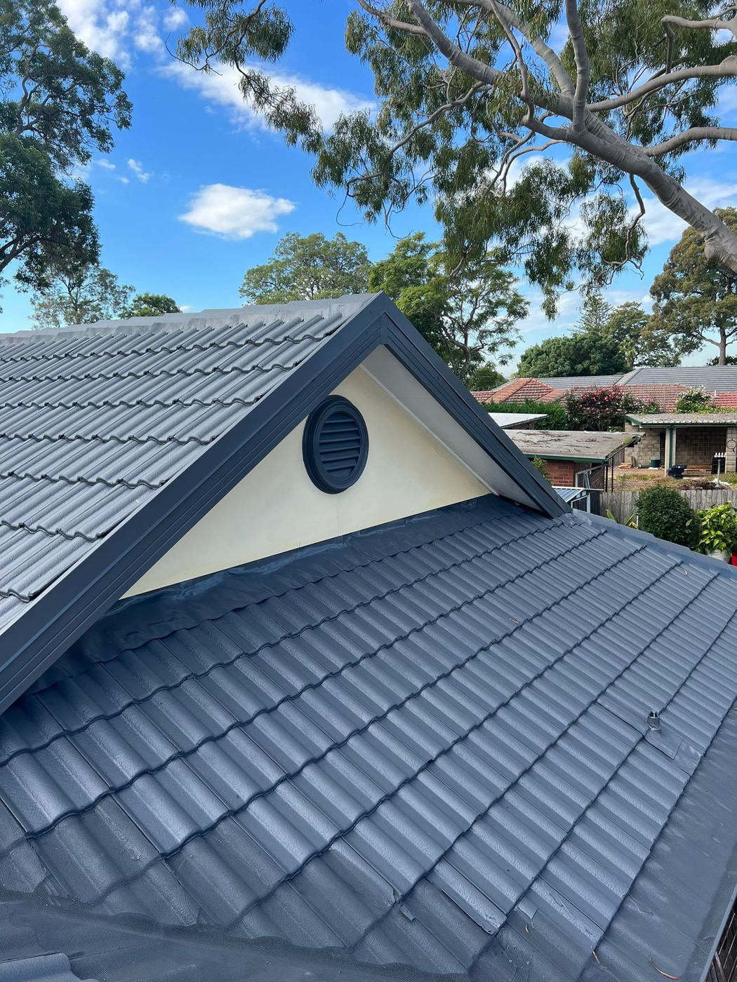 A charcoal grey tile roof after painting